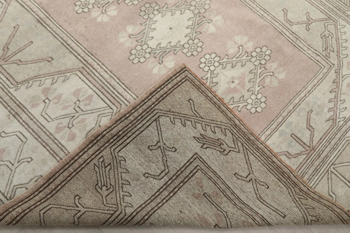Folded corner of the rug, showing the reverse side and knotting
