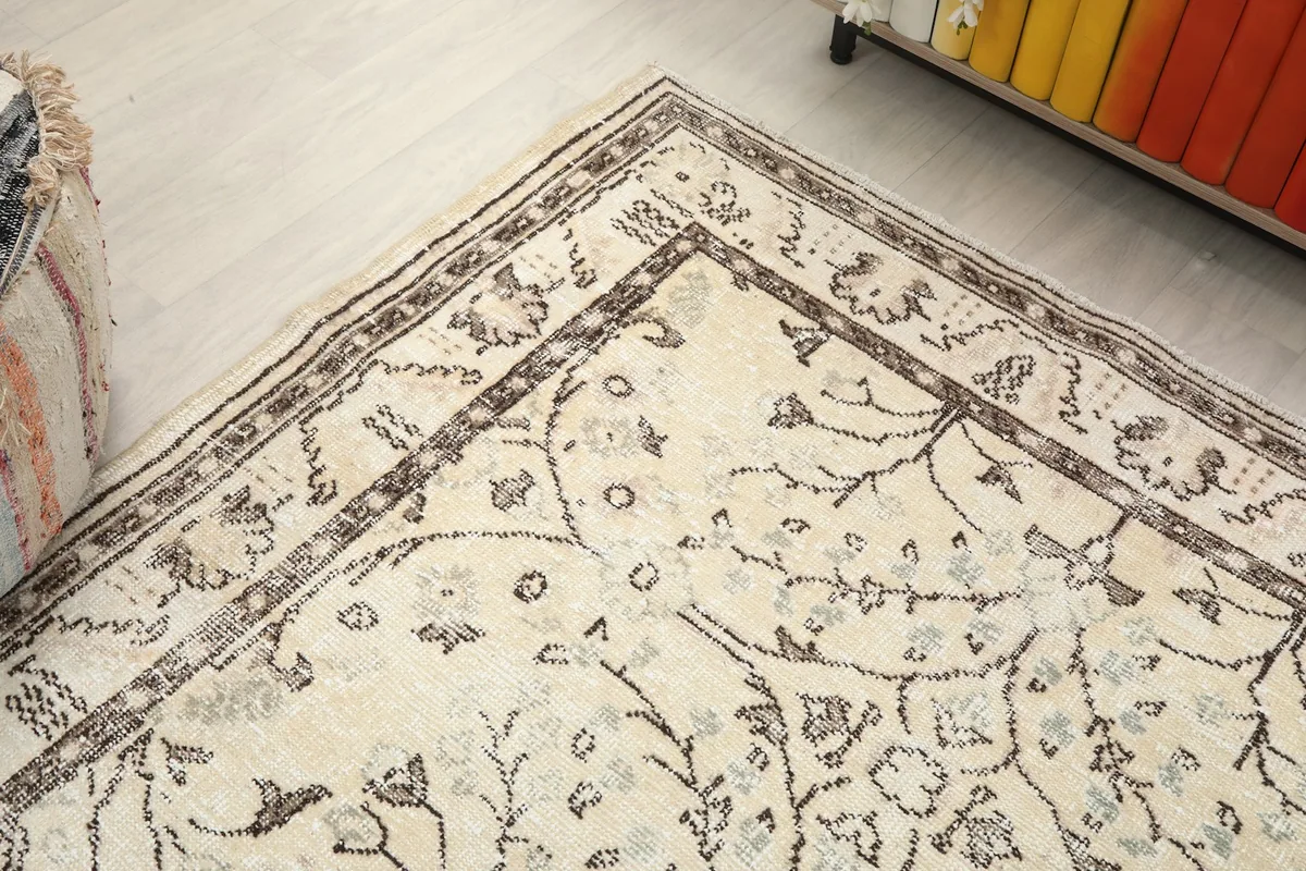 Angled view of the rug's corner, showing the distinct border and the faded ivory field