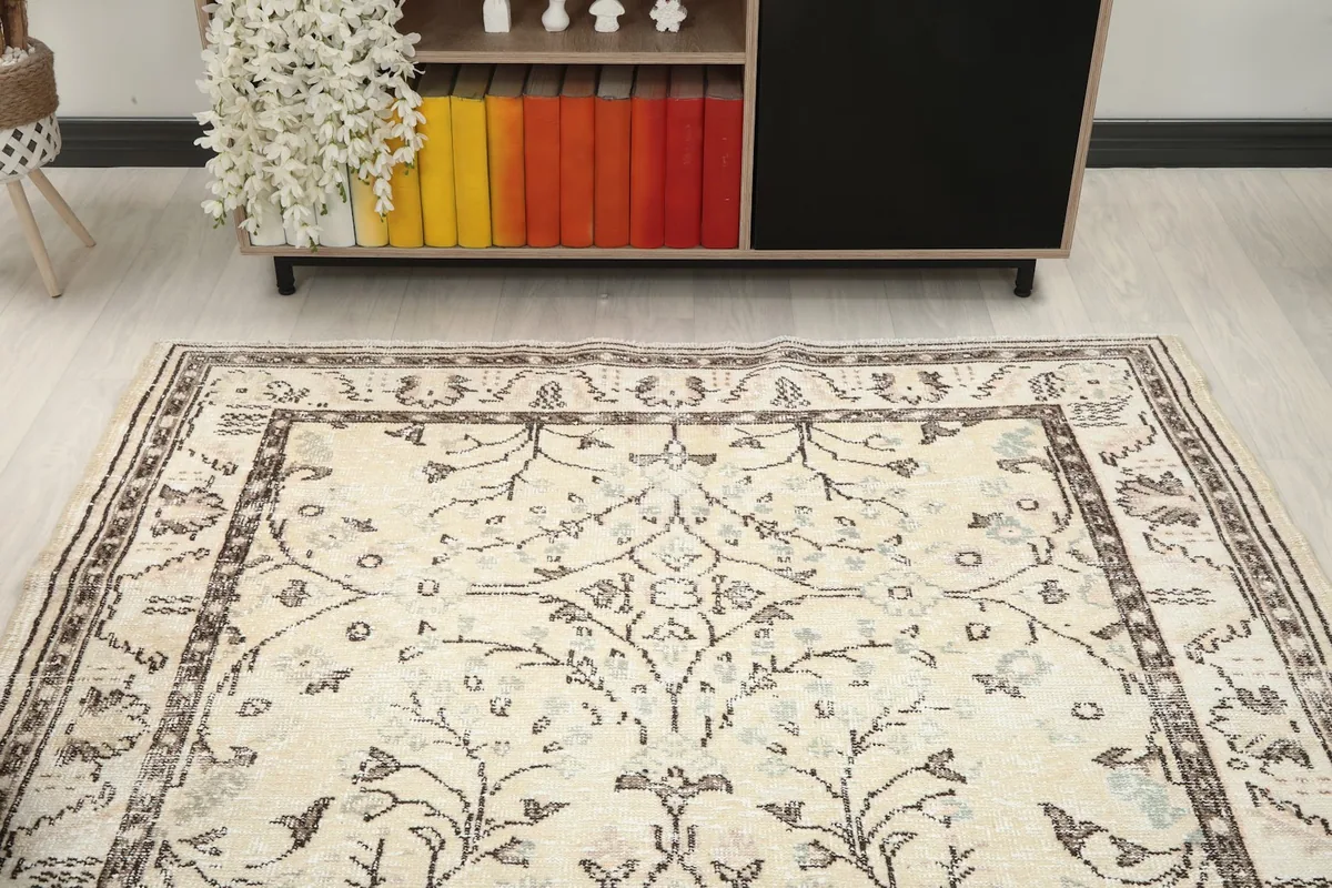 Overhead view of the ivory vintage rug in a room, focusing on the center and surrounding decor