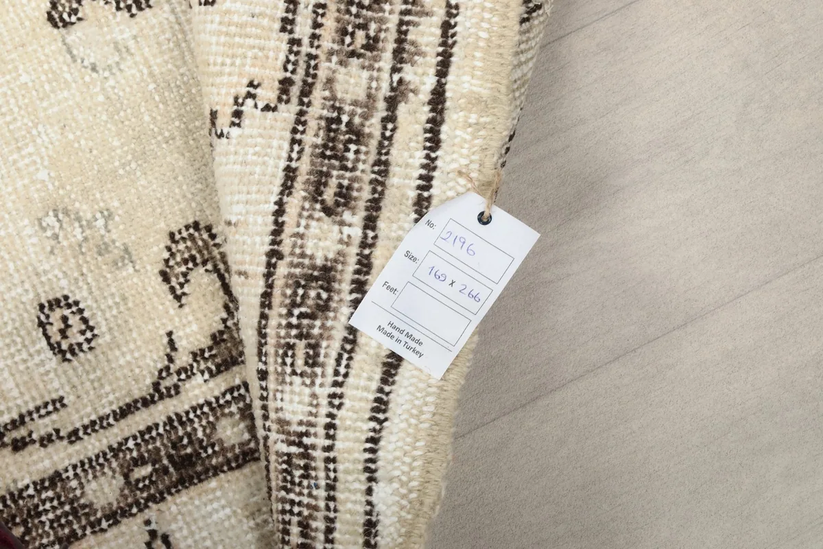 View of the rug's underside with a tag showing size information and origin