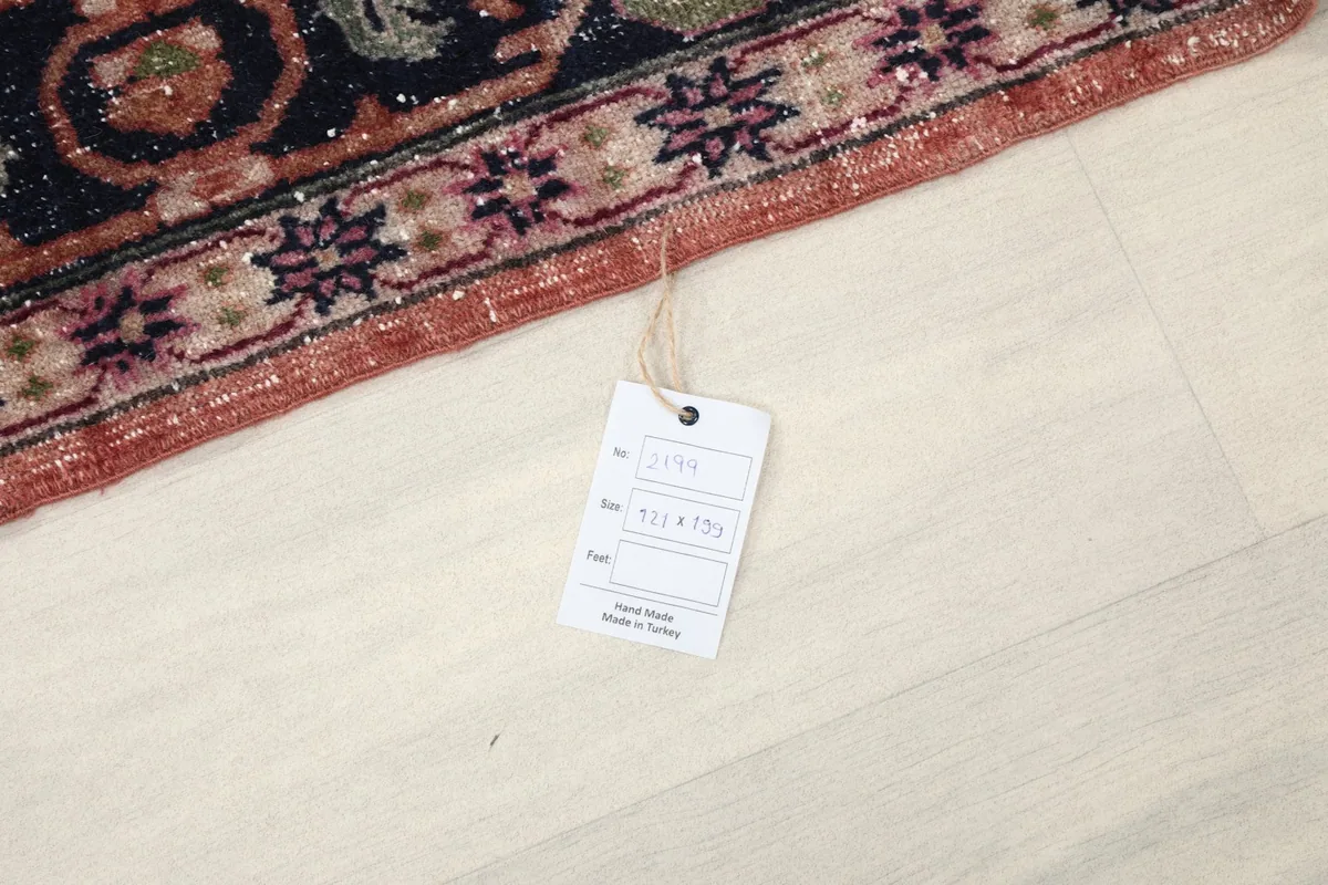 Close-up of the rug's edge with the product tag, indicating its origin and size.