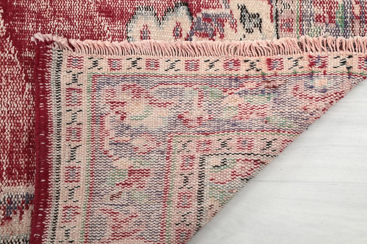 Close-up of the rug's short, natural cotton fringes and the tightly woven edge.