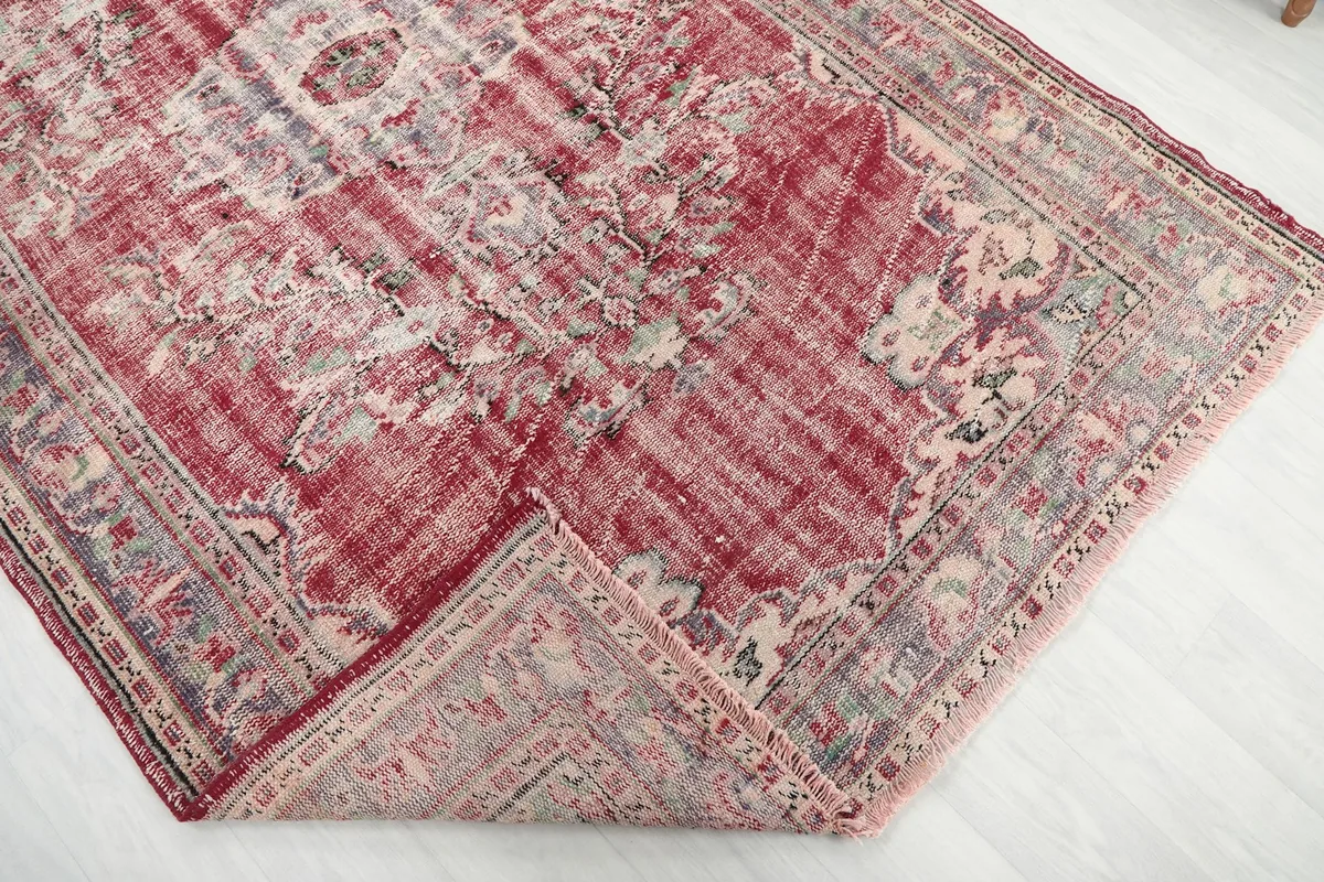 Folded corner of the rug, revealing the thickness of the hand-knotted wool pile and cotton foundation.