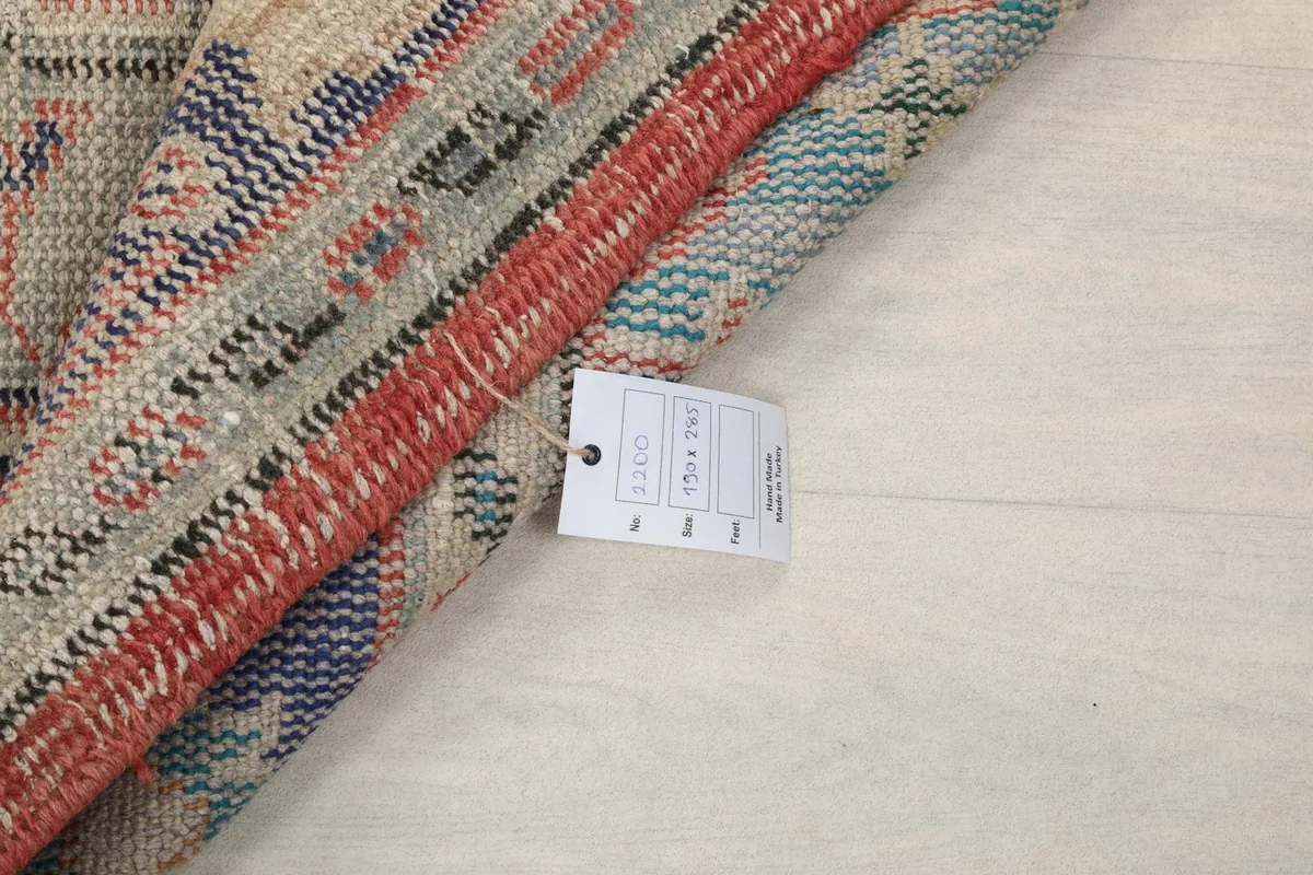 Rolled edge of the rug with the product tag visible, showing the thickness and material.