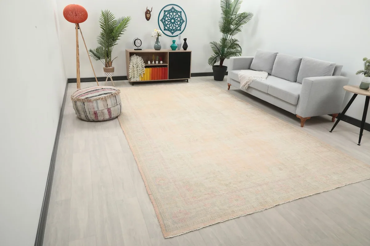 Angle view of the large beige and rose rug in a modern living space