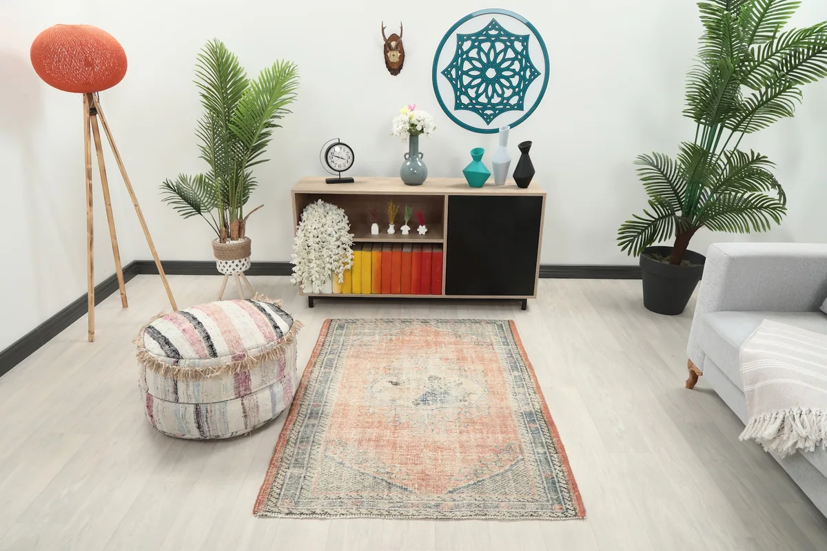 Vintage rust and blue Anatolian rug displayed in a bright living room setting with modern decor