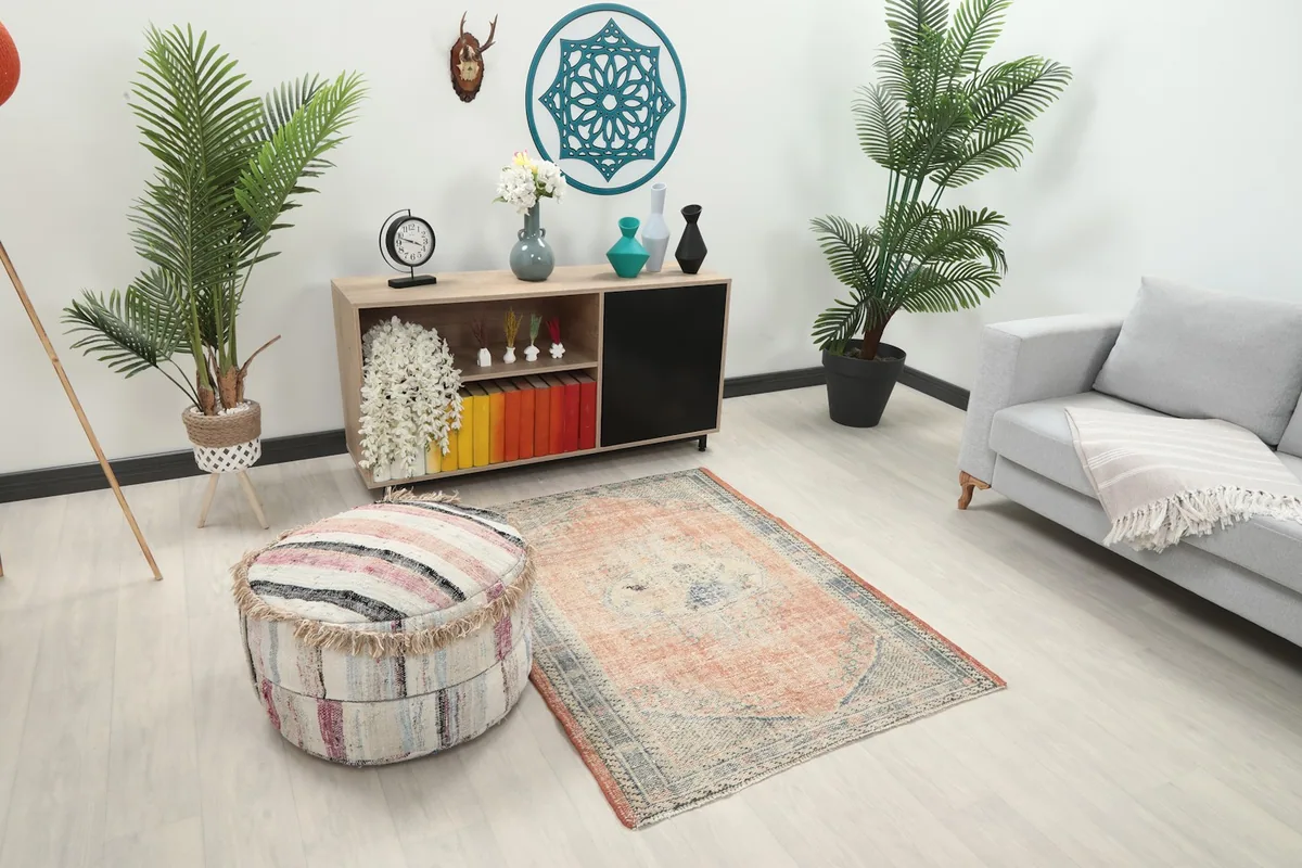 Angle view of the 4x5 Anatolian rug in a room, highlighting its size and placement next to an ottoman
