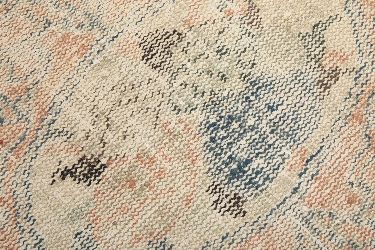 Texture detail of the low wool pile showing the hand-knotted weave and distressed appearance