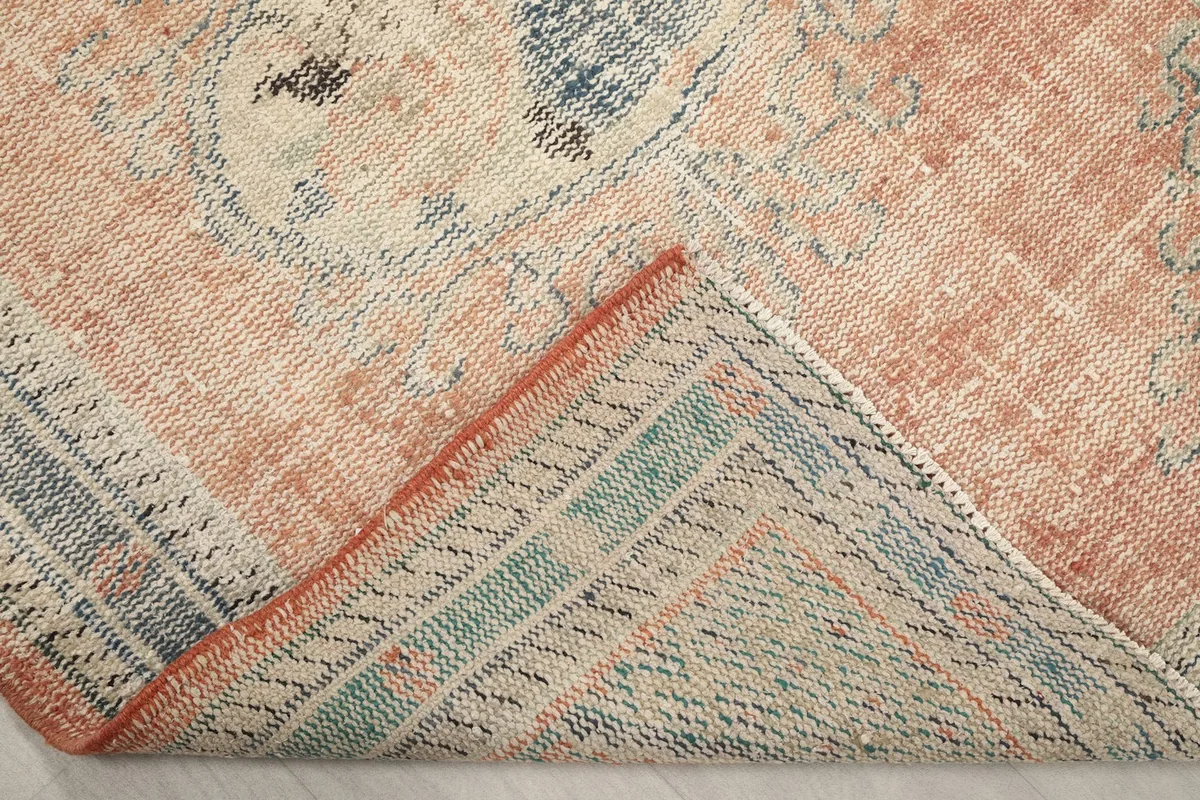 Folded corner showing the back of the hand-knotted wool pile on cotton foundation