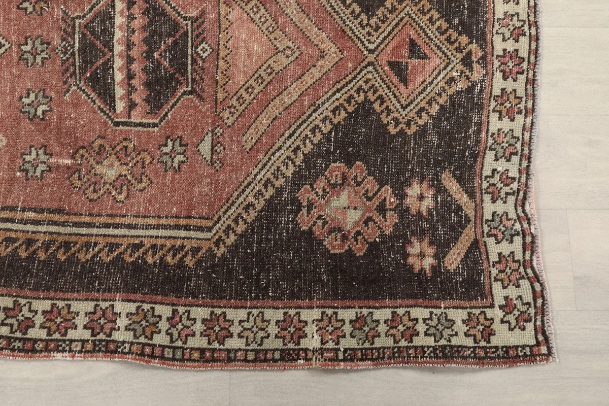 Detailed view of the charcoal border and corner of the vintage runner, highlighting geometric patterns