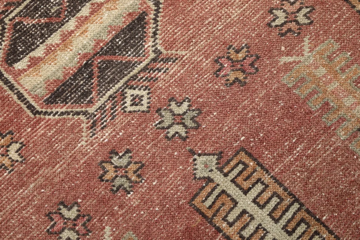 Texture and low pile of the hand-knotted wool rug, showing natural wear