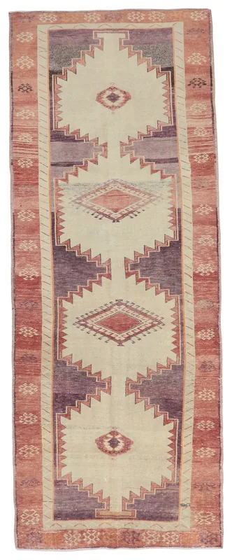 Full overhead view of the beige, purple, and rust vintage Anatolian runner rug on a white background.