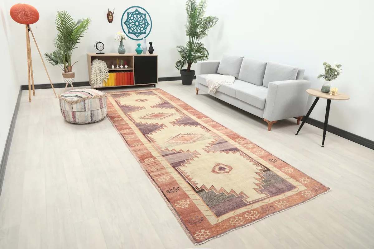 Angled view of the beige, purple, and rust tribal runner rug in a contemporary living space.
