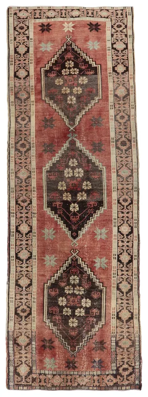 Full overhead view of a vintage Anatolian runner rug with rust field and geometric floral motifs