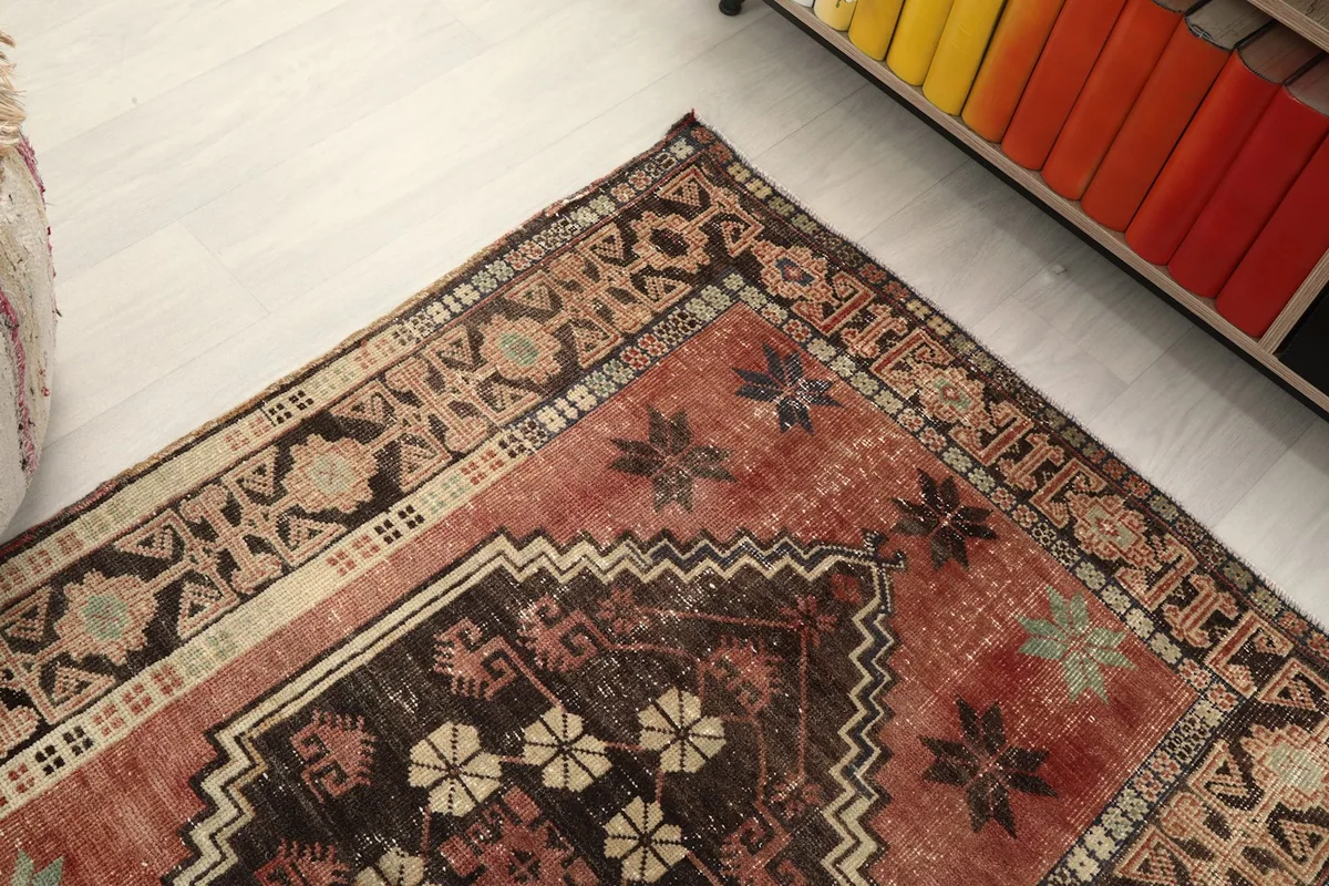 Corner view of the rug with its intricate border patterns and natural wear