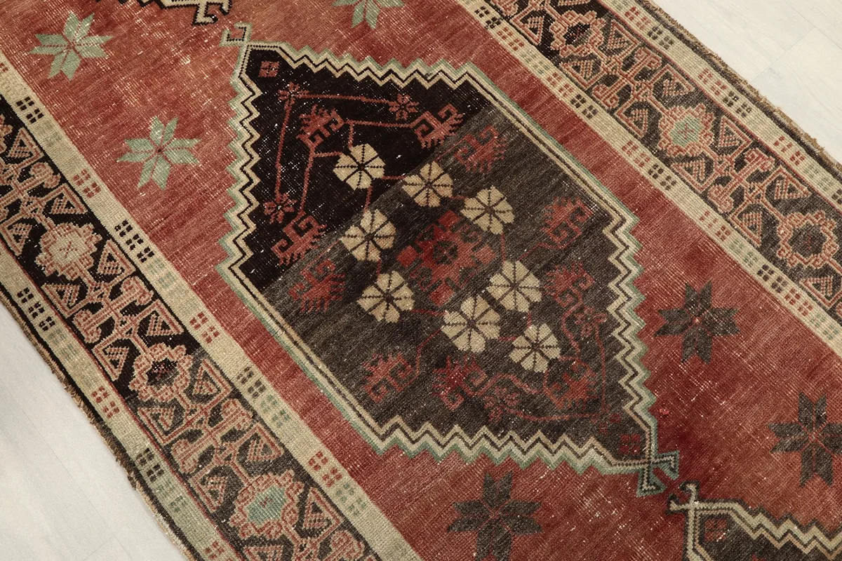 Close-up of a central diamond motif with floral designs and surrounding rust field