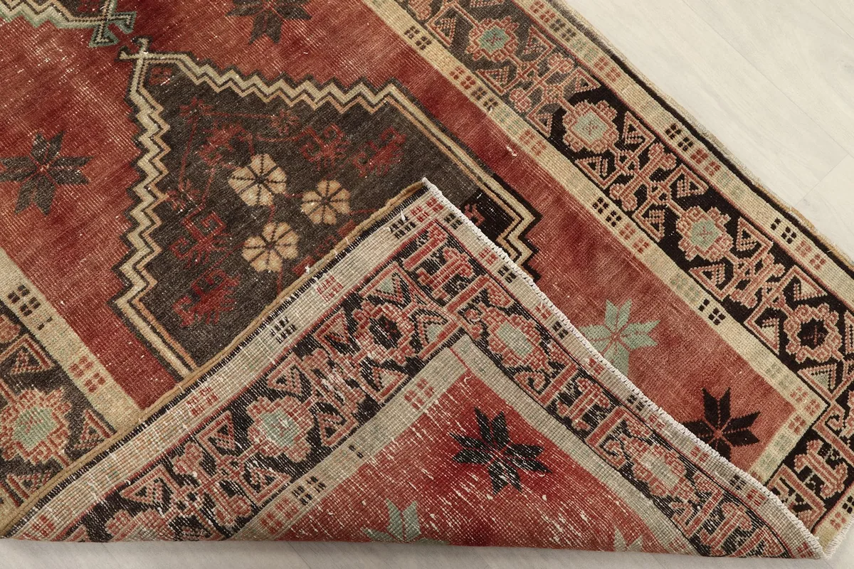 Folded corner of the rug showing the reverse side and pile thickness