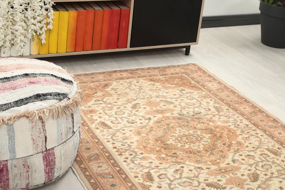 Close-up detail of the rug's surface, showing the cream field and rust and brown motifs.
