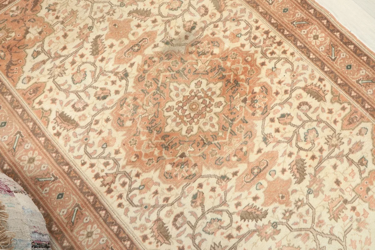 Overhead angled view highlighting the central medallion and surrounding floral patterns on the rug.