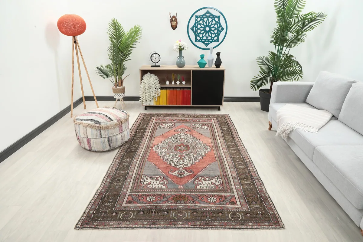 Area rug displayed in a living room setting with a sofa and pouf