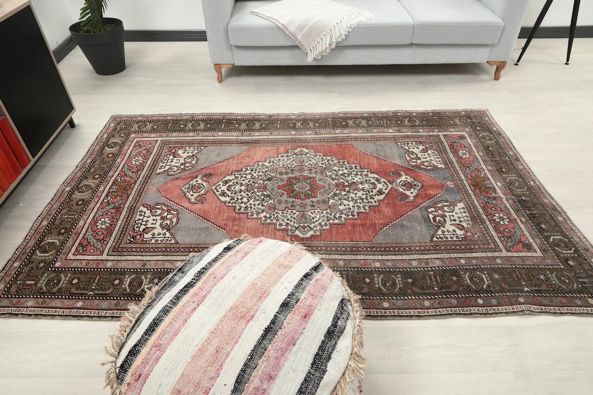 Overhead view of the rug in a room, with a pouf in the foreground