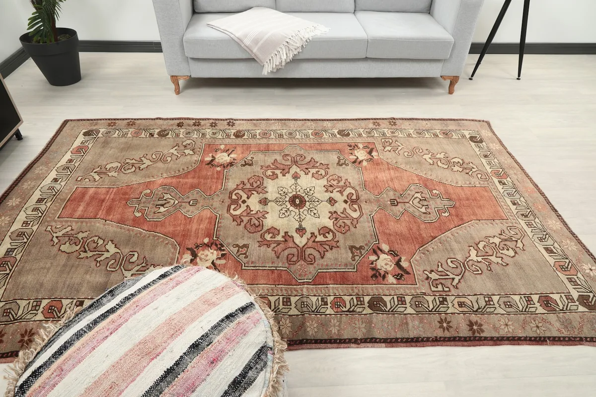 Wide shot of the rug laid out in the living space with a sofa and pouf