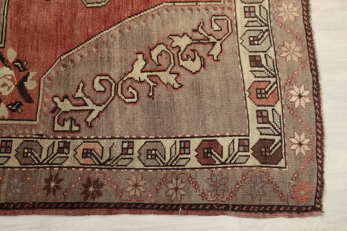Detailed view of the beige field with subtle floral motifs and the patterned border