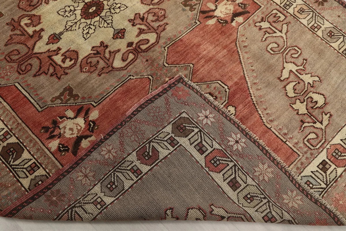 Corner of the rug folded back, revealing the hand-knotted cotton foundation