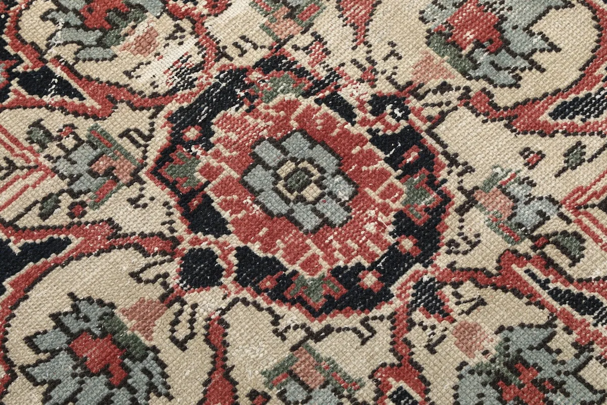 Macro shot showing the low wool pile and intricate knotting of the rug's pattern