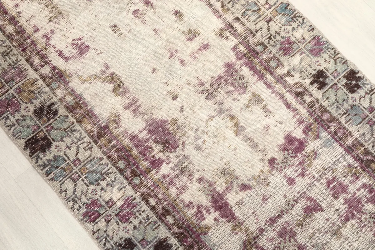 Angled view highlighting the distressed texture and color variations across the rug's surface