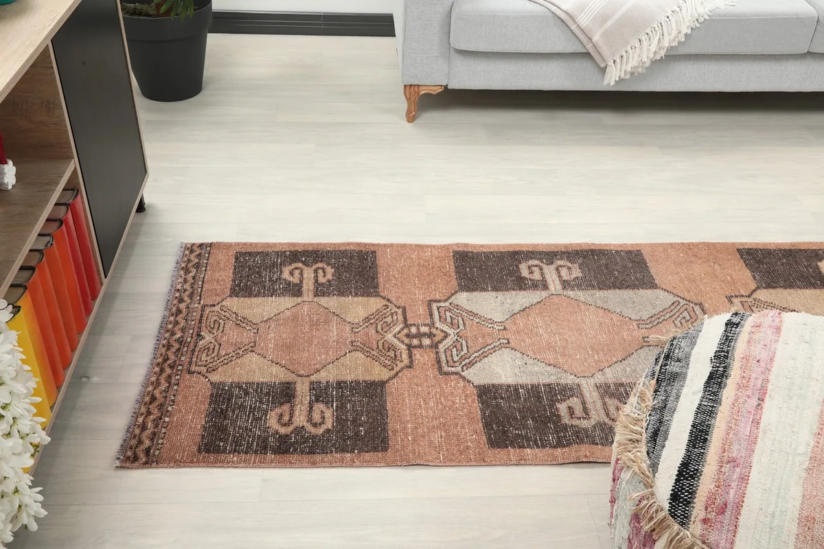 View of the runner rug stretching towards a sofa, captured from a lower angle