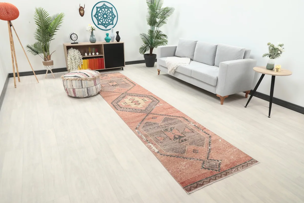 Angle view of the rust runner rug in a contemporary living room with a decorative ottoman