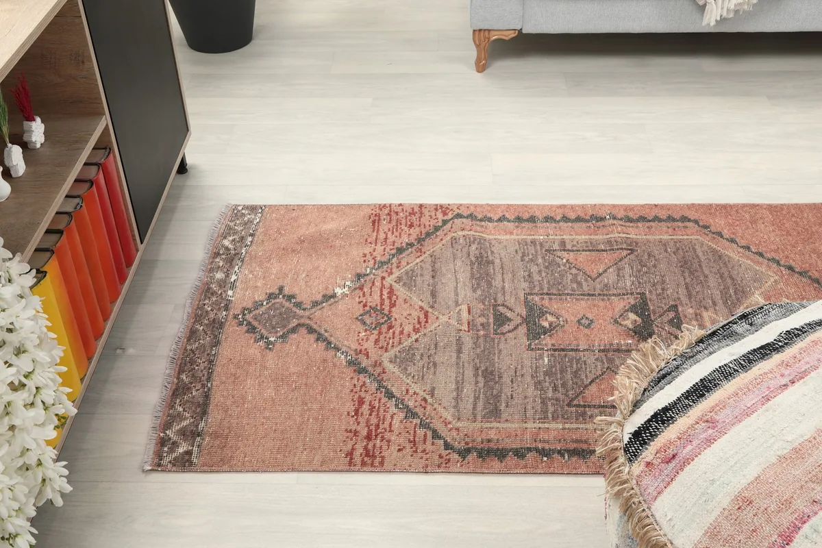Overhead view of the runner rug extending from a cabinet to an ottoman in a room