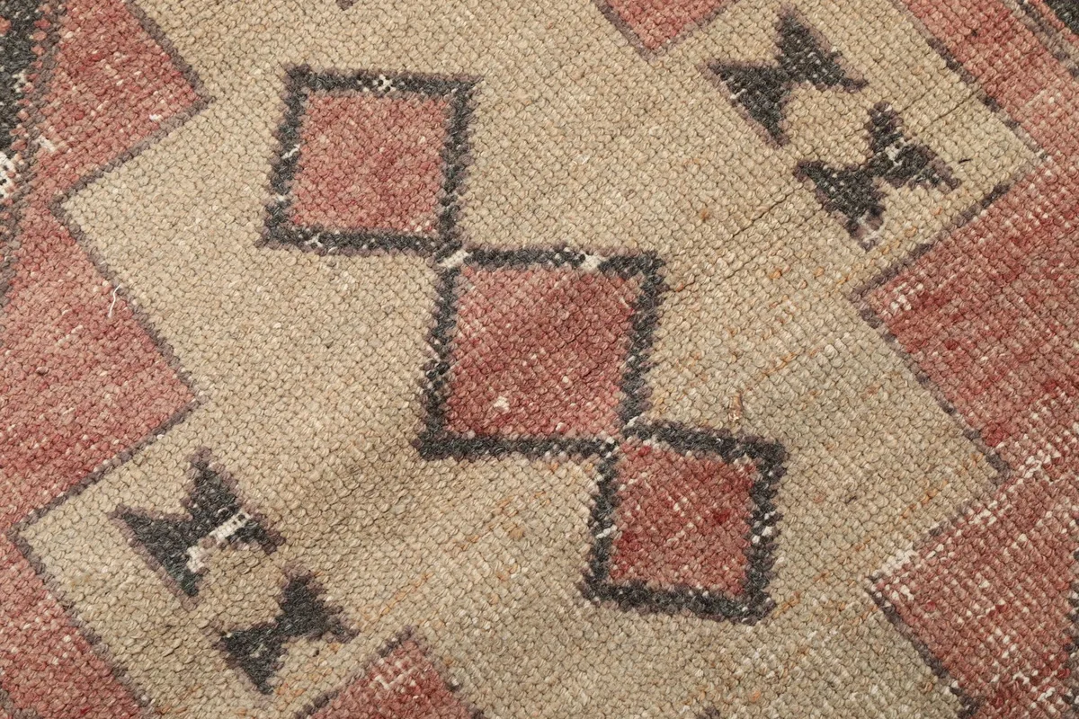 Detailed shot of the interlocking beige and rust squares within a charcoal motif