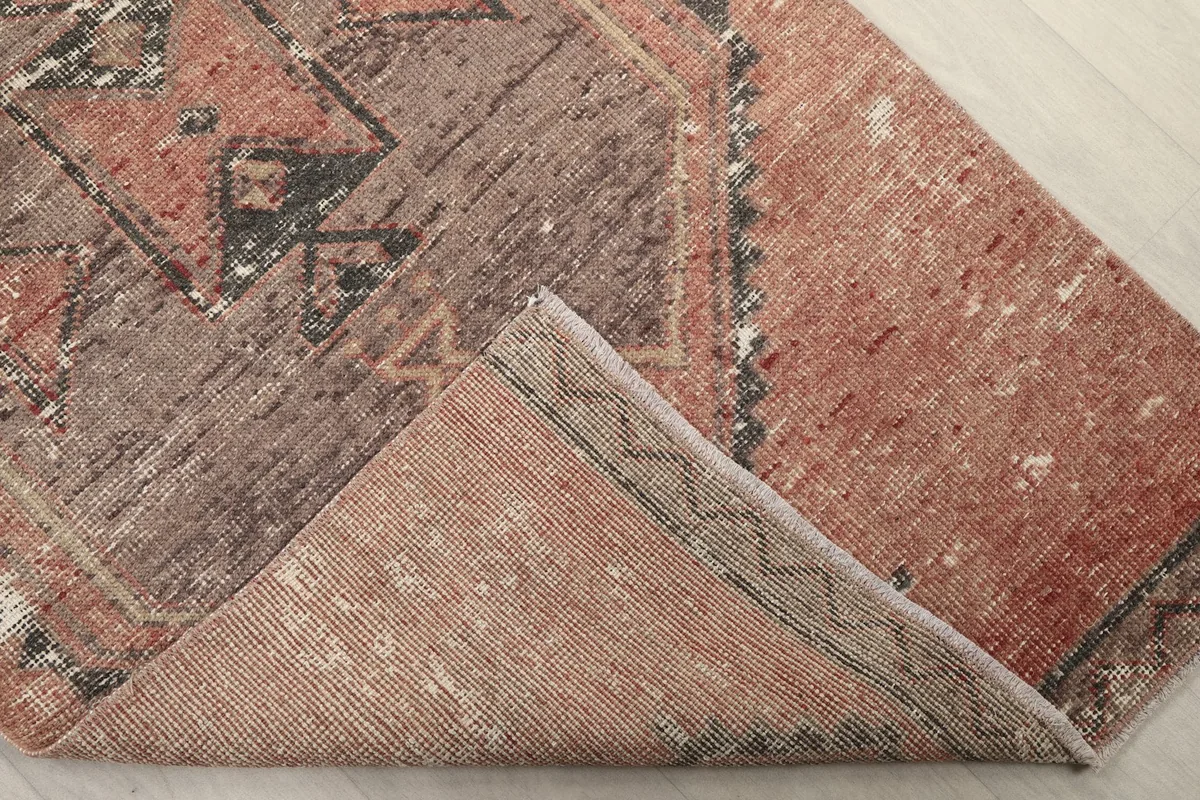 Folded corner showing the reverse side of the hand-knotted rug and its cotton foundation