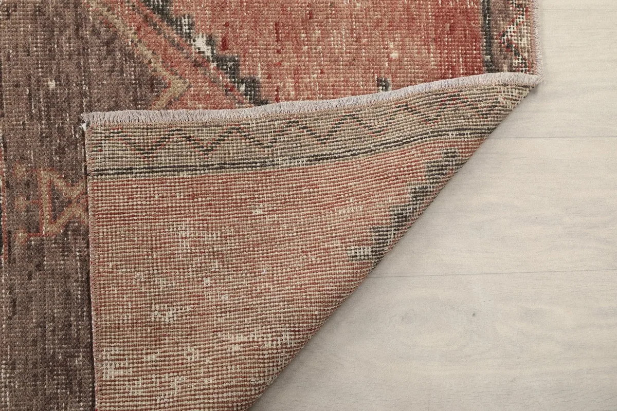 Another folded corner displaying the back of the rug, knots, and foundation texture
