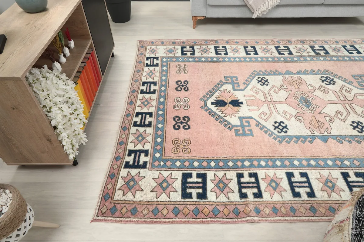 Side angle of the pink and navy rug complementing a light-colored floor and modern furniture