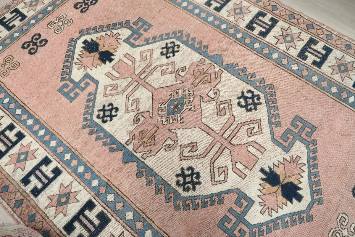 Close-up of the central ivory medallion with pink and navy accents and tribal motifs