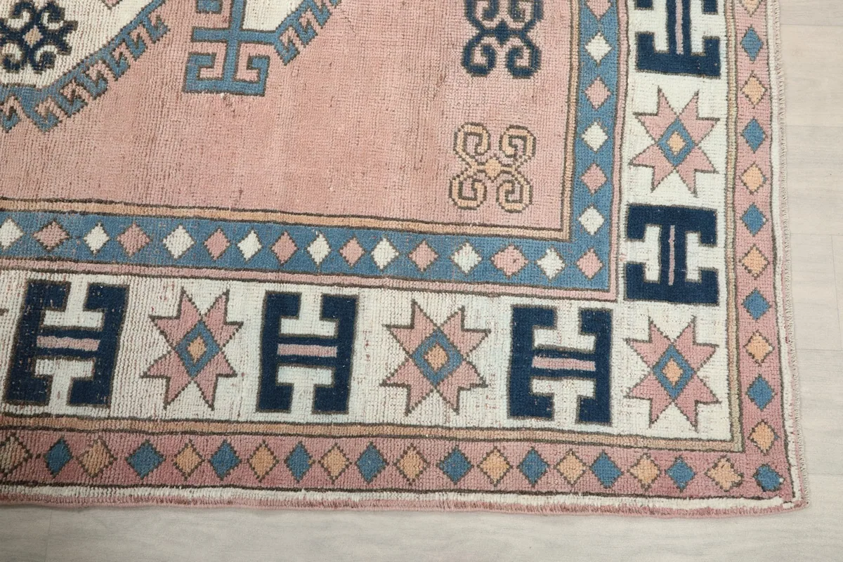 Detailed view of the corner border design with navy, ivory, and pink geometric star motifs
