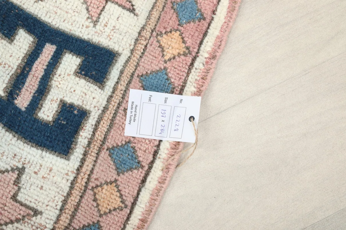 Close-up of the size tag attached to the rug, showing its dimensions and origin details