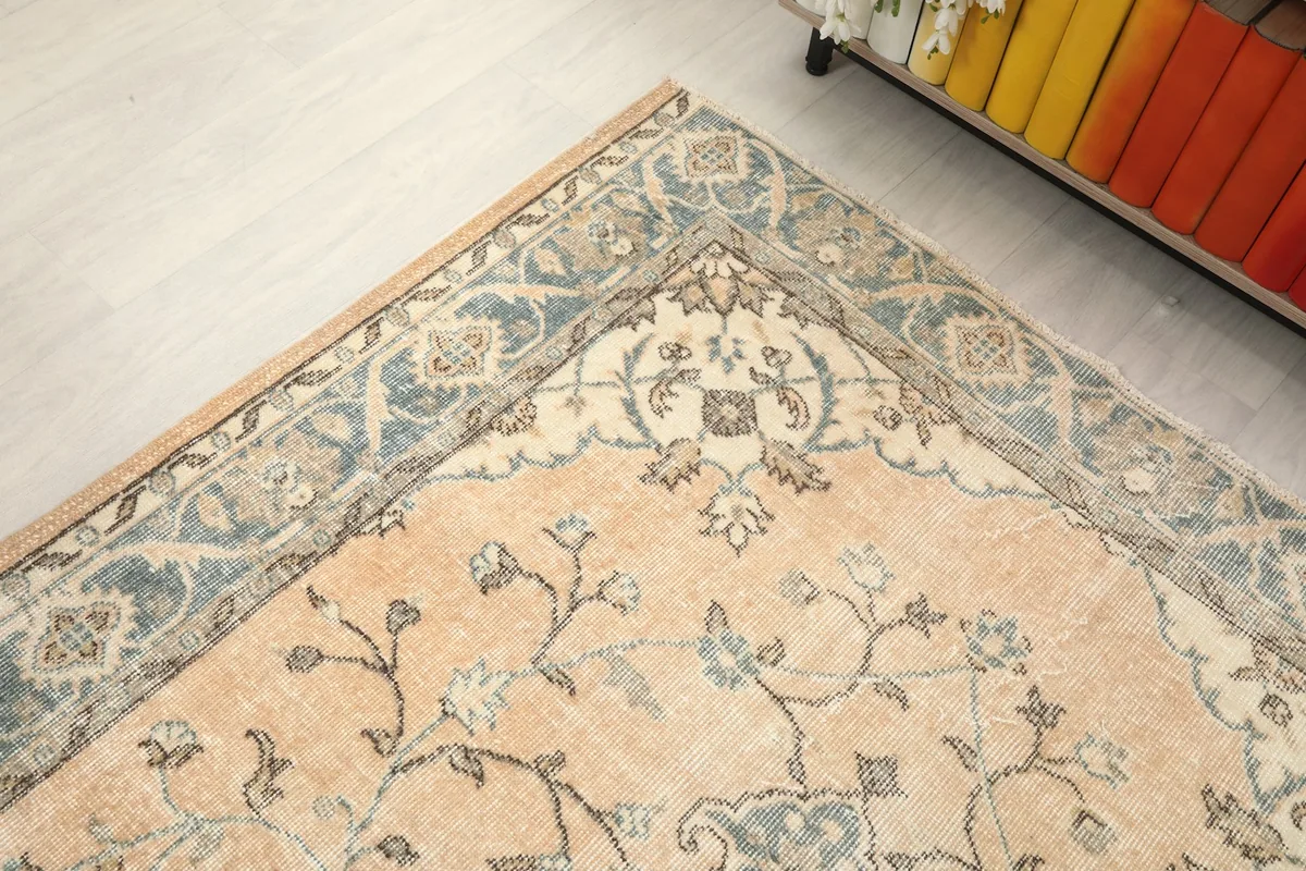 Corner detail of the rug showing the transition from the beige field to the gray border in a room