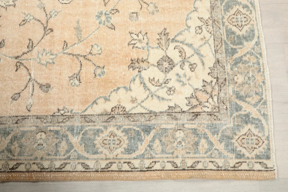 Detailed view of the rug's gray border design with intricate floral and geometric motifs