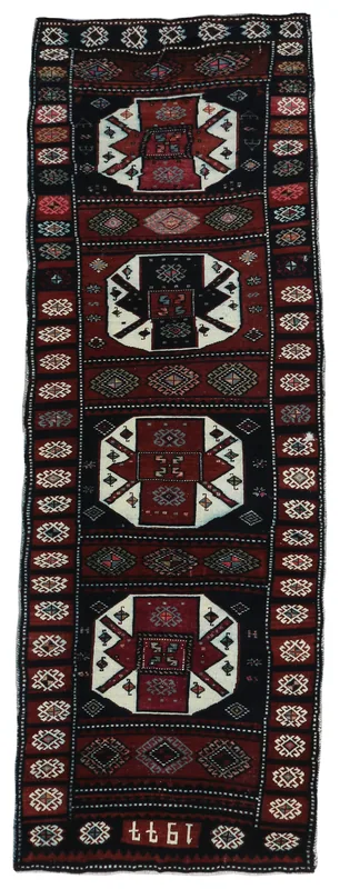 Full top view of the black and red geometric Anatolian runner rug on a white background