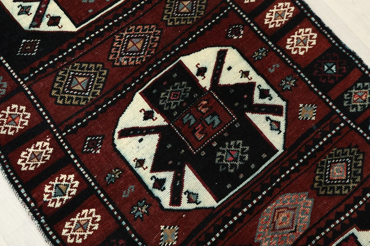 Close-up of a central red and ivory geometric medallion with intricate details