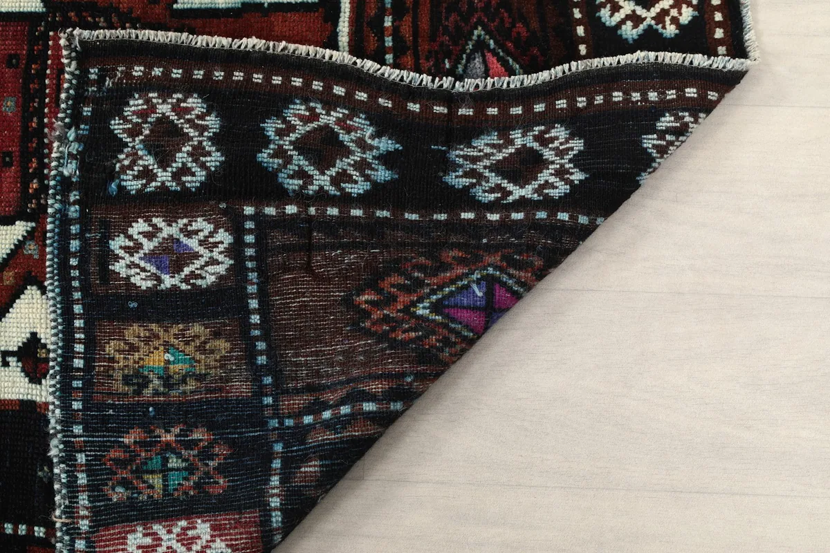 Close-up of the back of the rug, showing the wool pile knots on the cotton foundation