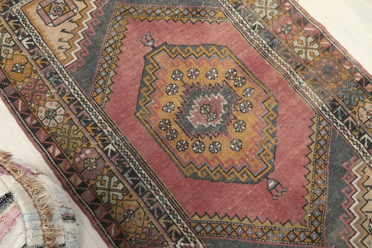 Overhead angle view highlighting the rose field and gold and charcoal geometric medallion.