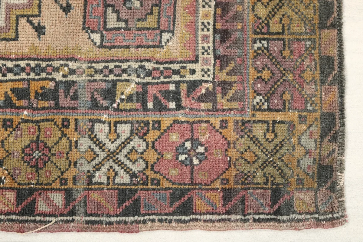 Detailed view of the intricate geometric patterns and colors in the rug's outer border.