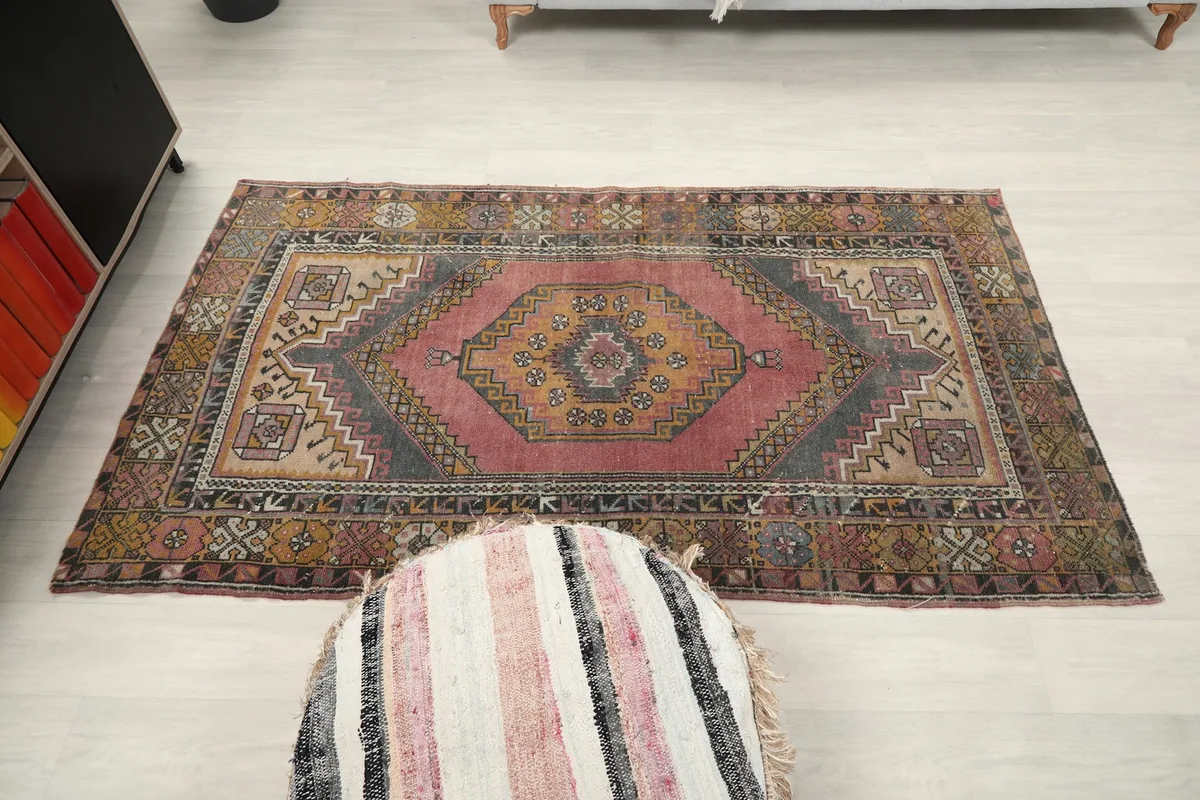 Straight overhead view of the vintage rug, capturing its full shape and design on the floor.