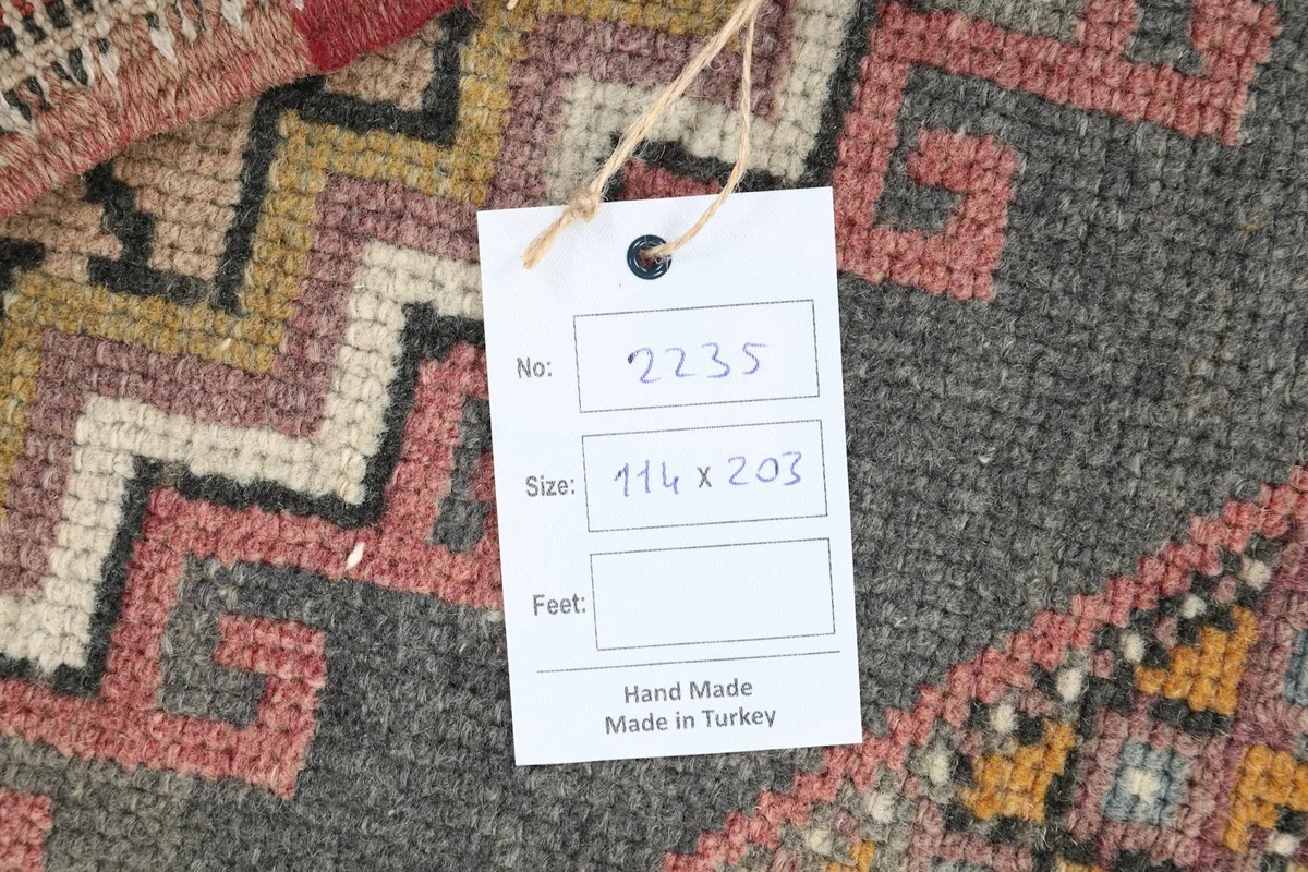 Close-up of a product tag on the rug, indicating its size in centimeters and origin.