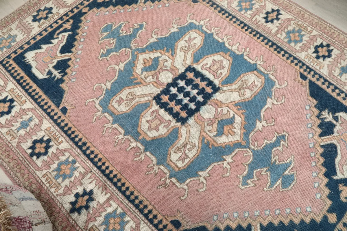 Close-up of the central medallion design on the pink and blue vintage Anatolian rug.